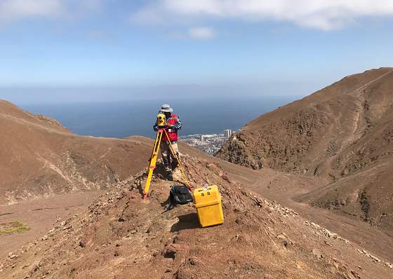 Estación total instalada en un cerro con vista al valle